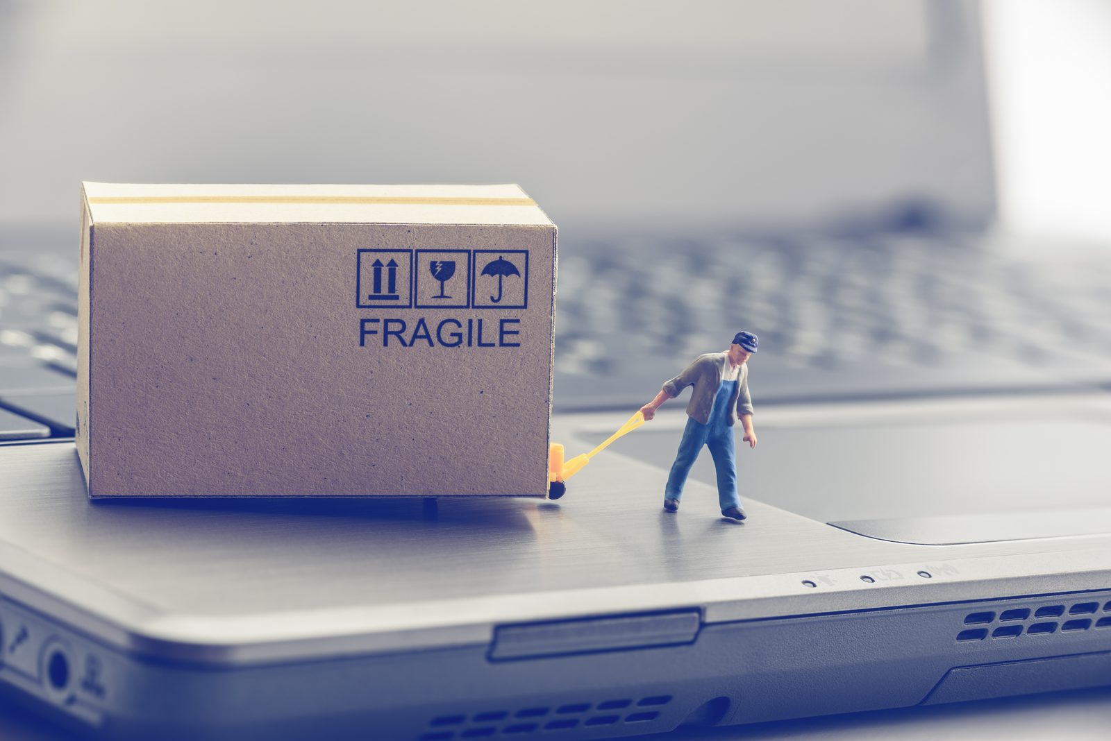 Miniatuurfiguren verplaatsen pakjes op een laptop