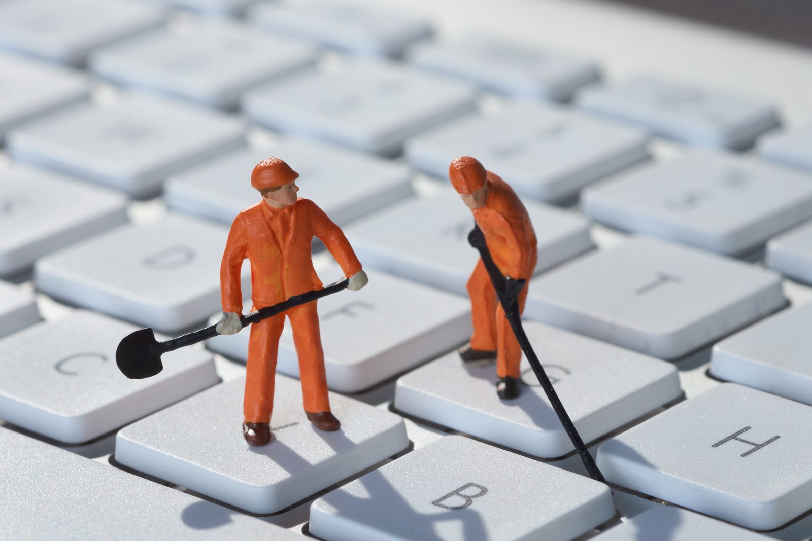 Miniatuur-vakmannen aan het werk op een toetsenbord