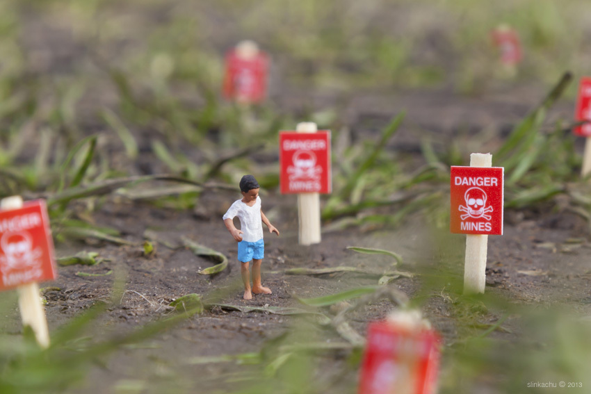 Miniatuurfiguur tussen rode waarschuwingsvlaggetjes