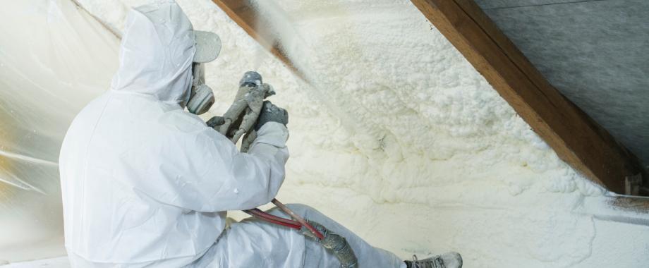 Persoon in wit beschermingspak verwijdert isolatiemateriaal