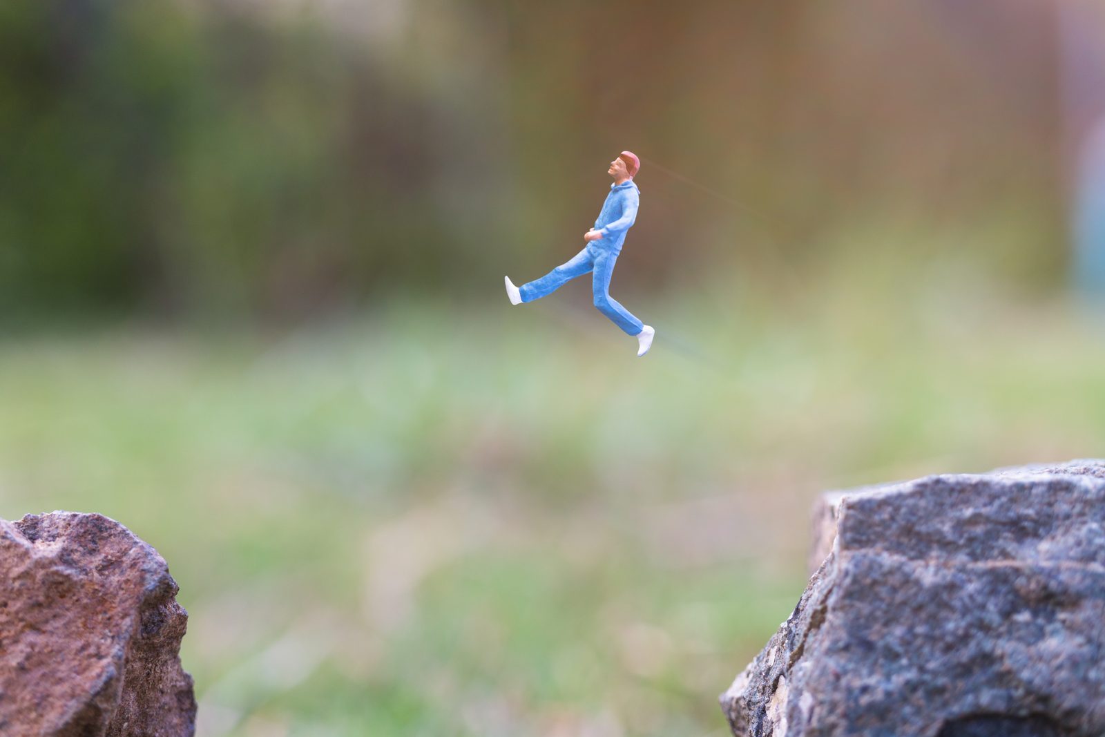 Figuur springt van de ene rots naar de andere
